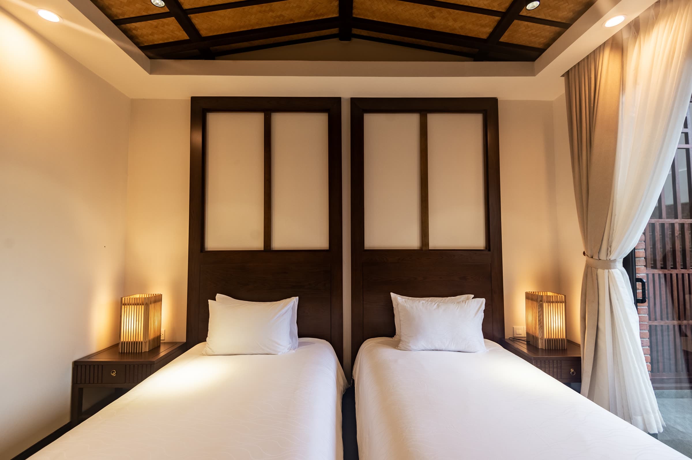 The two single beds of the Ying and Yang twin room beneath a vaulted timber ceiling