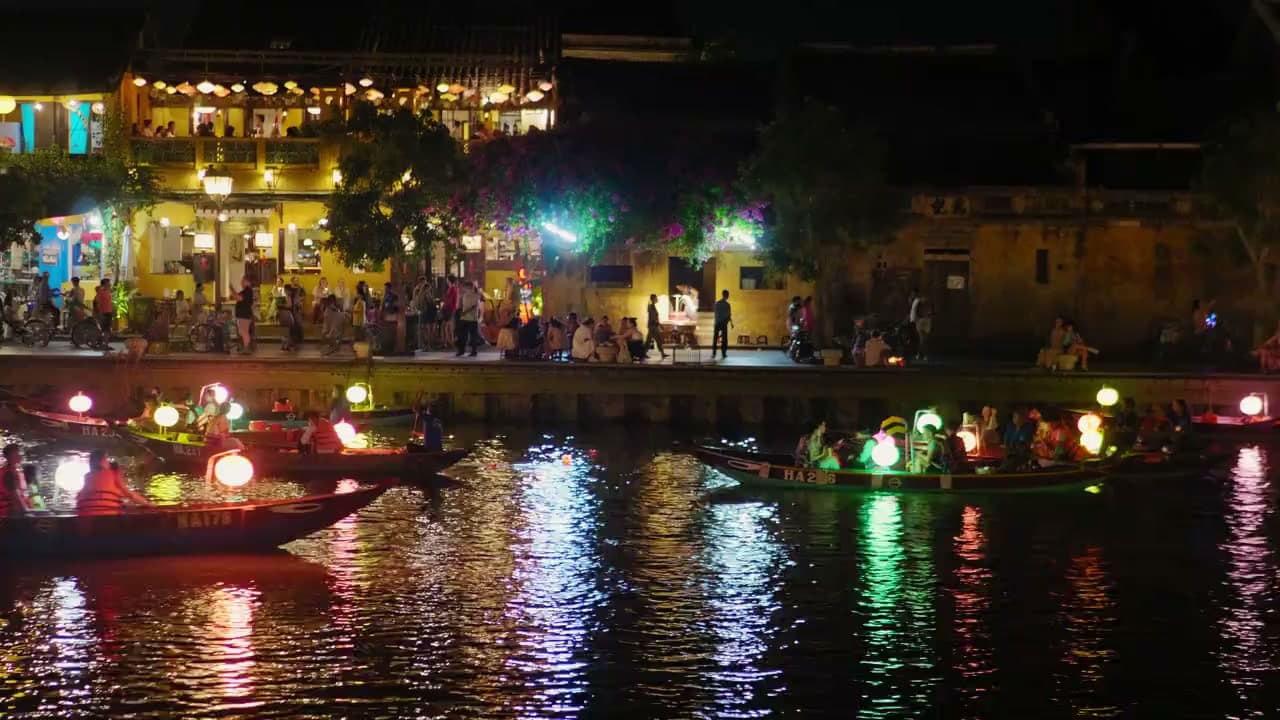Stunning aerial view of Hội An, Vietnam at sunset. City lights illuminate the historic riverside town.